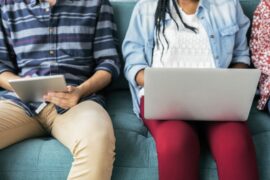 couple on couch with tablet and laptop