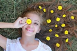 teenage girl in field with flowers in hair