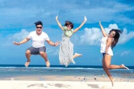 three friends jumping on beach