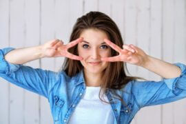 woman framing blue eyes with fingers