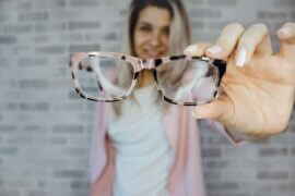 woman holding glasses out in front of her