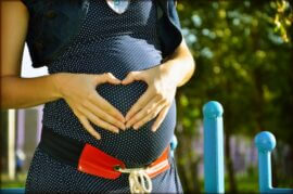 woman with hands on pregnant belly