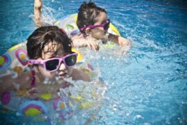 young kids in pool with floaters