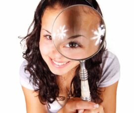 young woman looking through magnifying glass