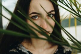 young woman peeking through leaves