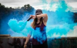 young woman with blue smoke bomb